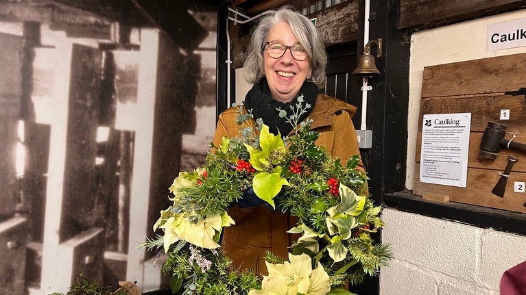 Visitor holding a beautiful wreath she has made